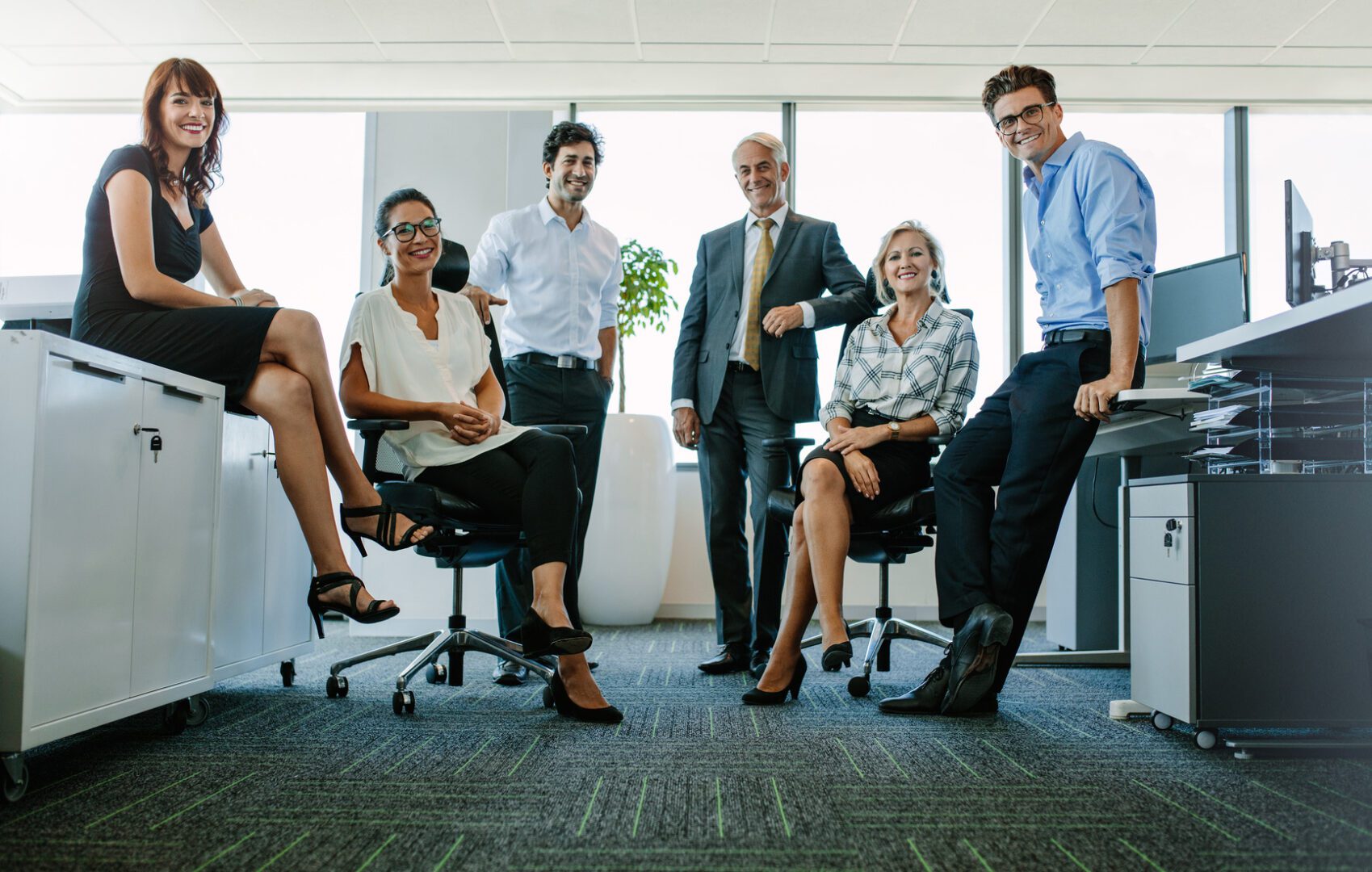 Portrait of successful business people at office Full length portrait of successful business people looking at camera and smiling. Businessman and businesswoman together in office.
