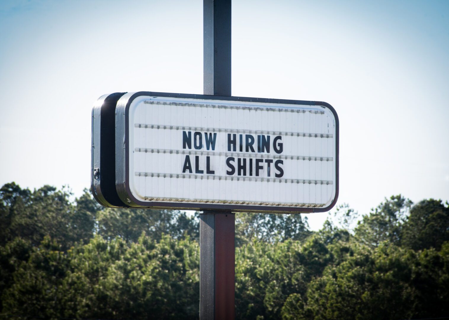"Now Hiring All Shifts" Sign A business openly advertises work opportunities.